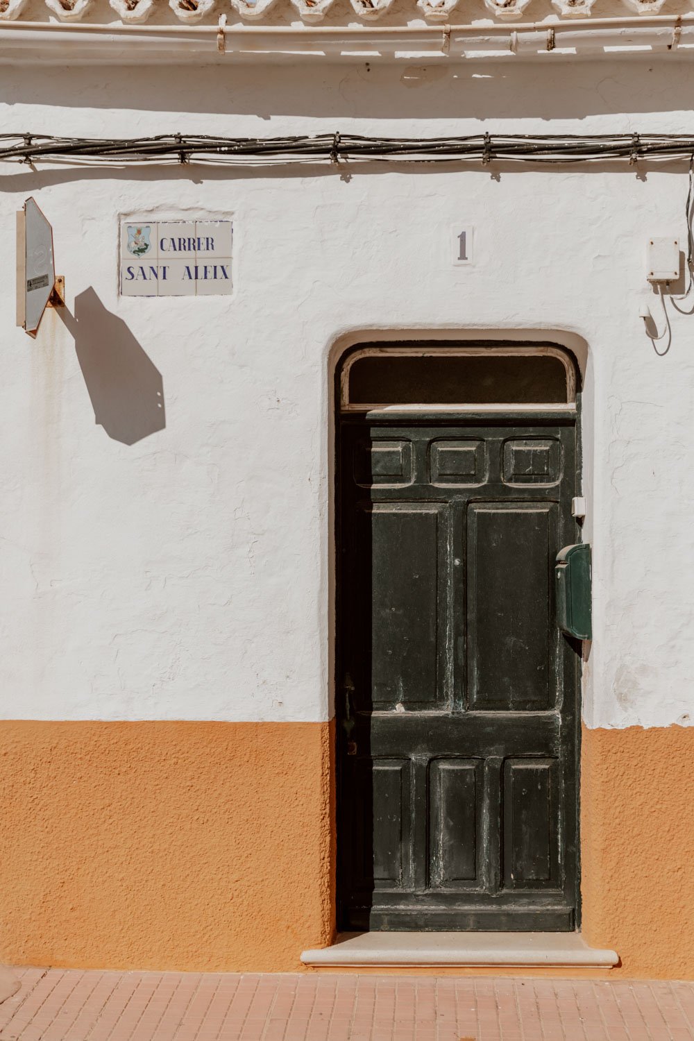 green-door-orange-white-wall